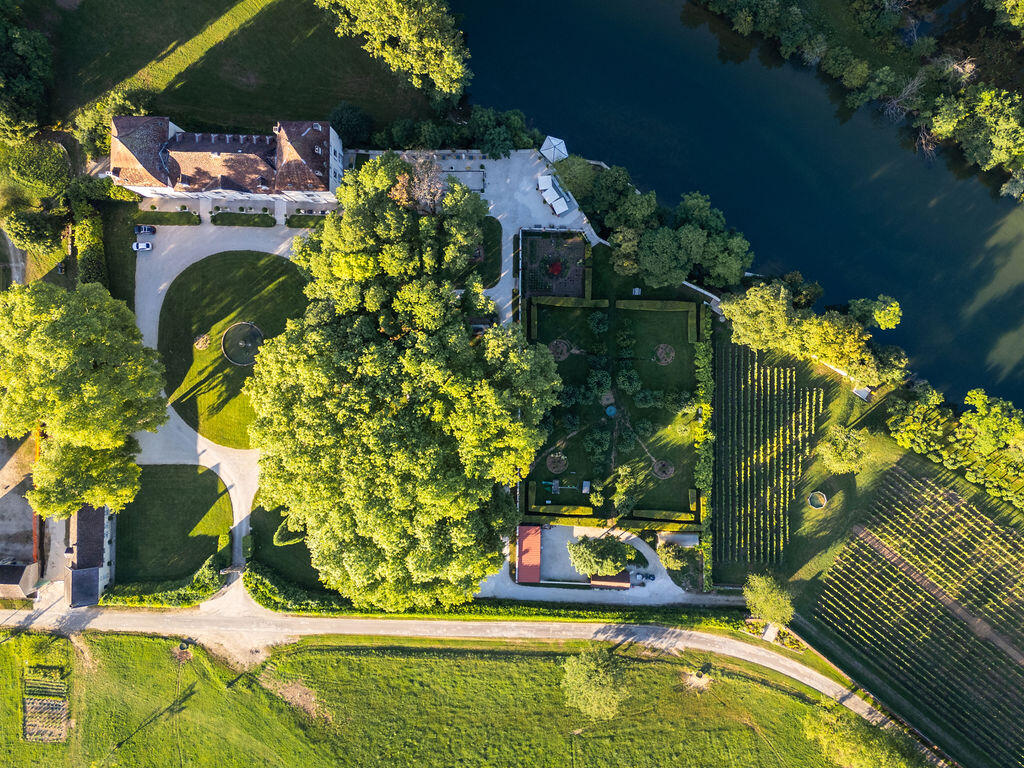 Aerial view of Château de Roche, its formal gardens, vineyard and the river Loue