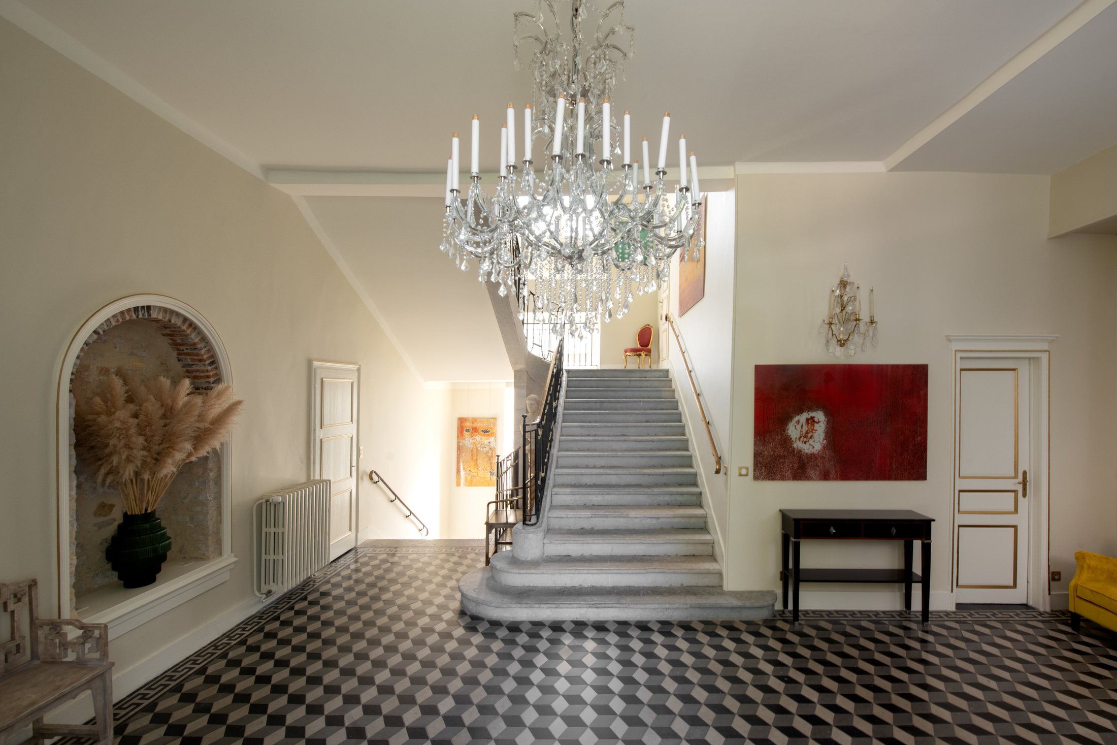 Le hall d’entrée du château, son damier de pierre sous le lustre de cristal