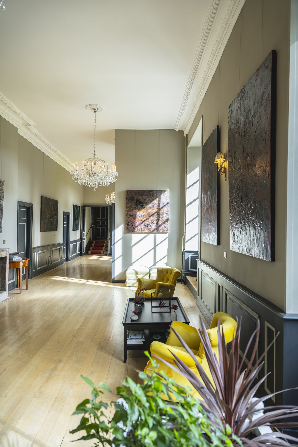 La galerie accrochée de tableaux, des fauteuils le long du mur