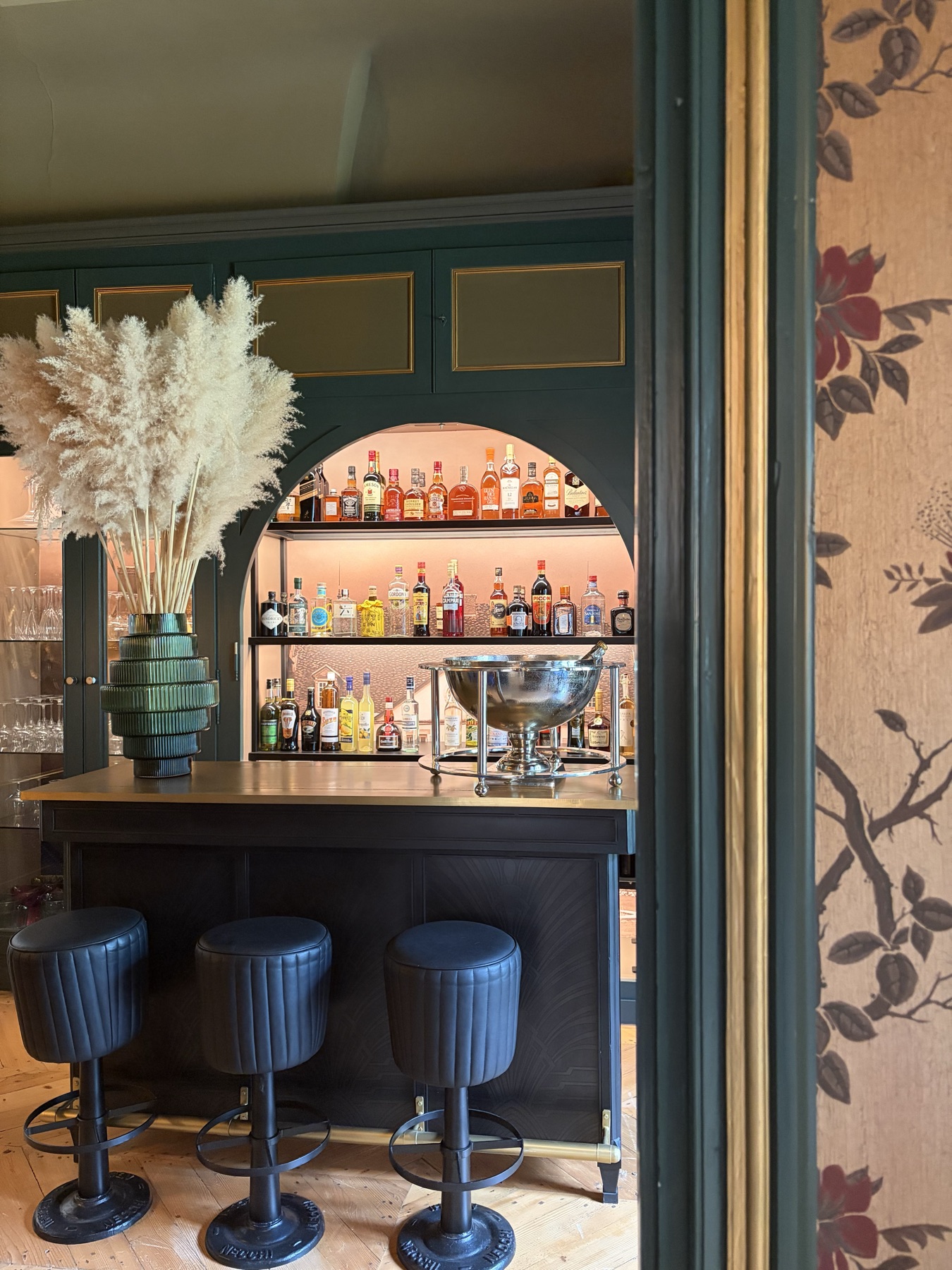 Le bar de la galerie de face, ses trois tabourets et sa vasque à champagne sous l’arche
