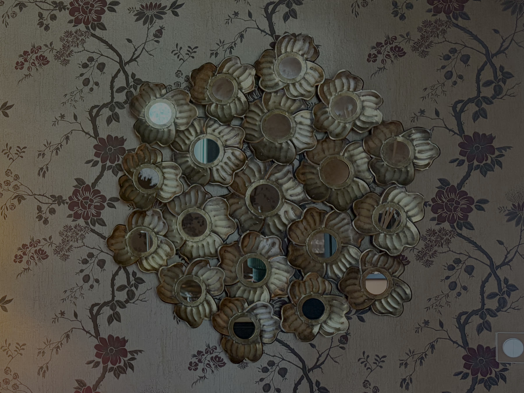 Un miroir en fleurs de métal sur le papier peint fleuri, près du bar