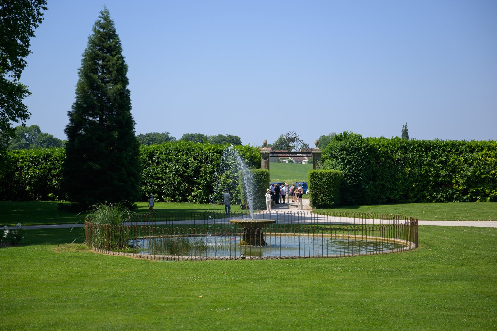 La pelouse et le bassin devant le château, bordés de haies taillées