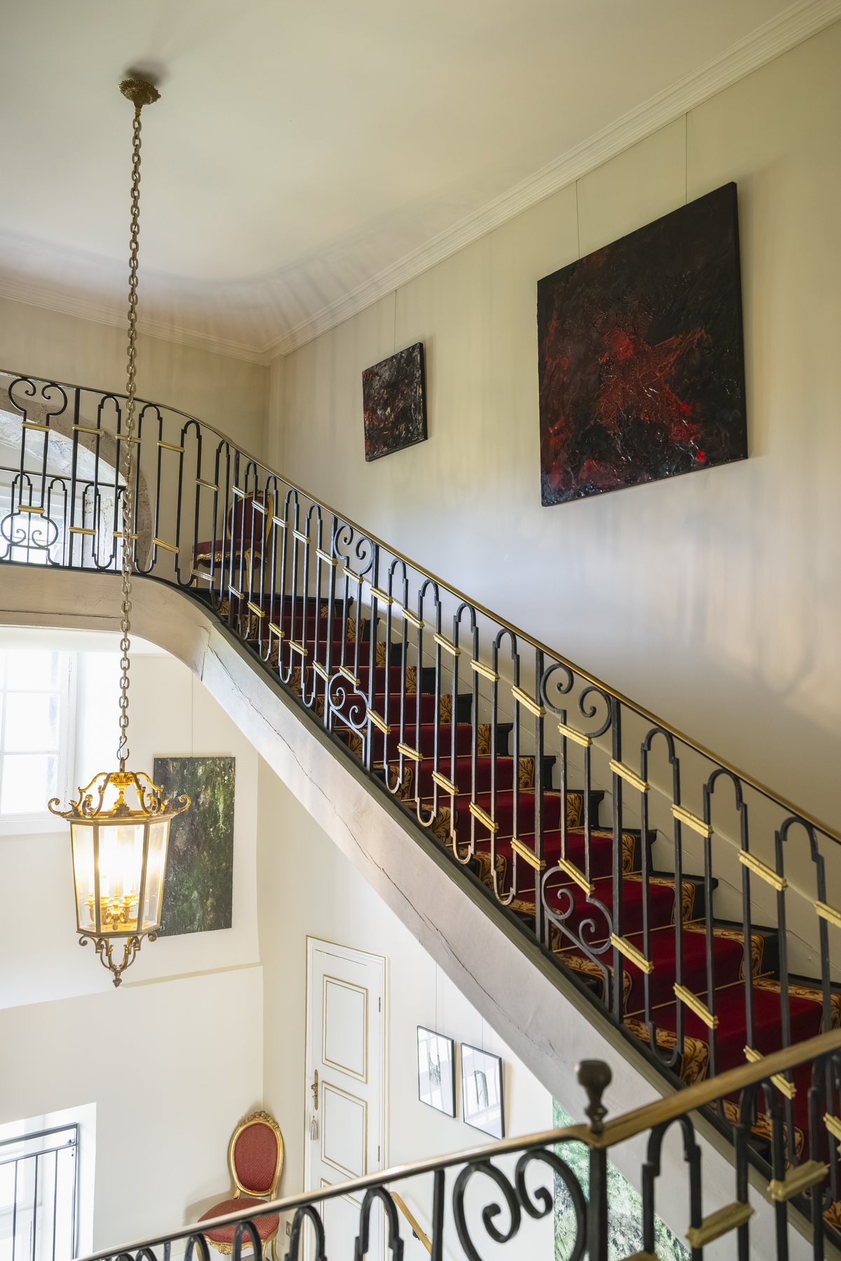 L’escalier vu d’en bas, sa lanterne suspendue dans la cage